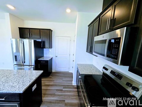 A kitchen with black cabinets and a granite countertop.