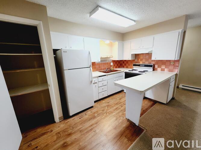 A kitchen with white appliances and a white island.