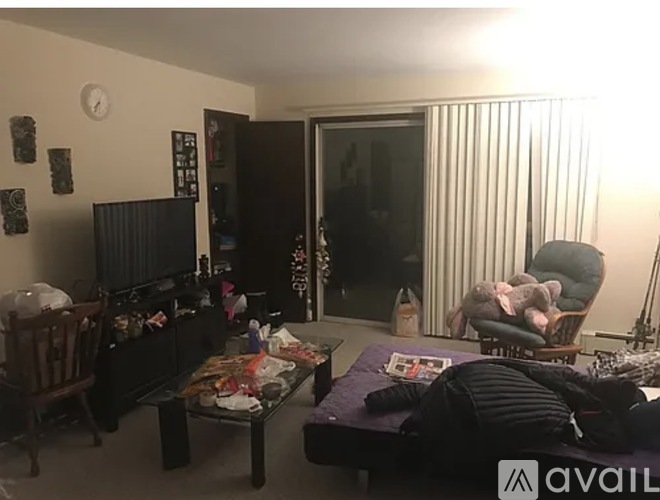 A living room with a couch, a chair, a coffee table, and a television.