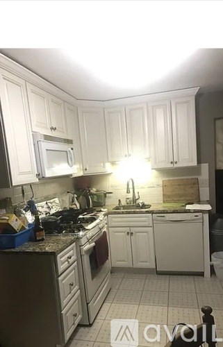 A kitchen with white cabinets and a granite countertop.