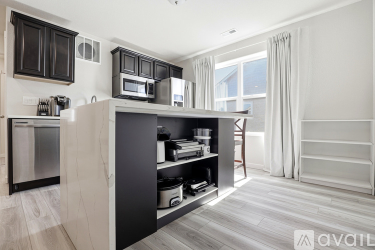 A modern kitchen with dark wood cabinets and stainless steel appliances.