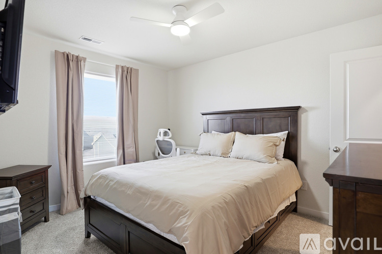 A bedroom with a large bed and a flat screen TV mounted on the wall.
