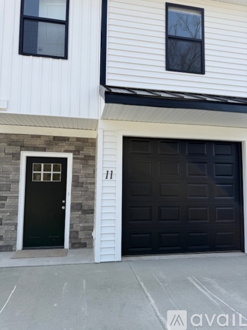 A house with a black door and a garage door.