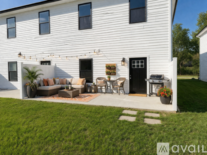 A white house with a patio and outdoor furniture.