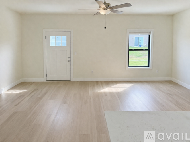 A room with a ceiling fan and two doors.