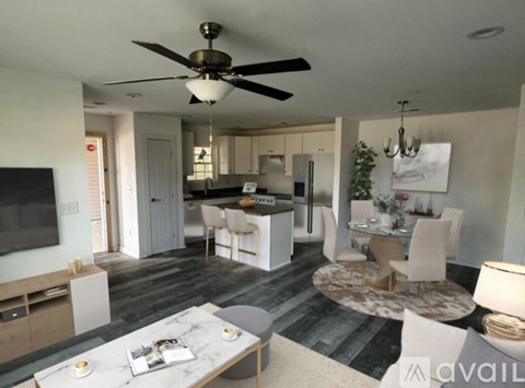 A modern living room with a kitchen in the background.