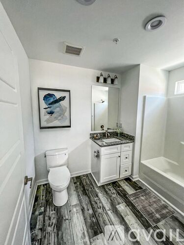 A bathroom with a toilet, sink, and mirror.