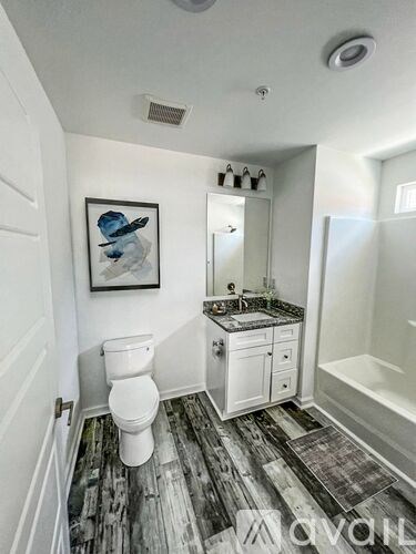 A bathroom with a toilet, sink, and mirror.