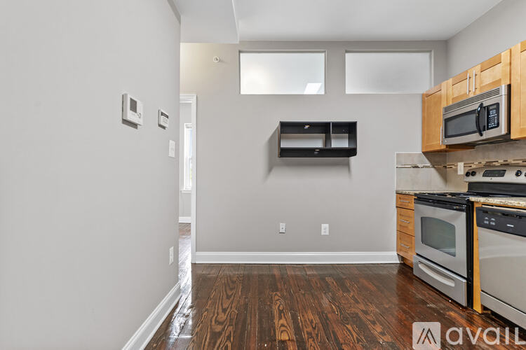 A kitchen with wood floors and white walls.