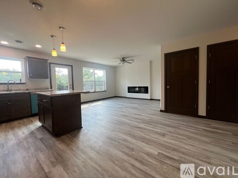 A spacious living room with wood flooring and a ceiling fan.