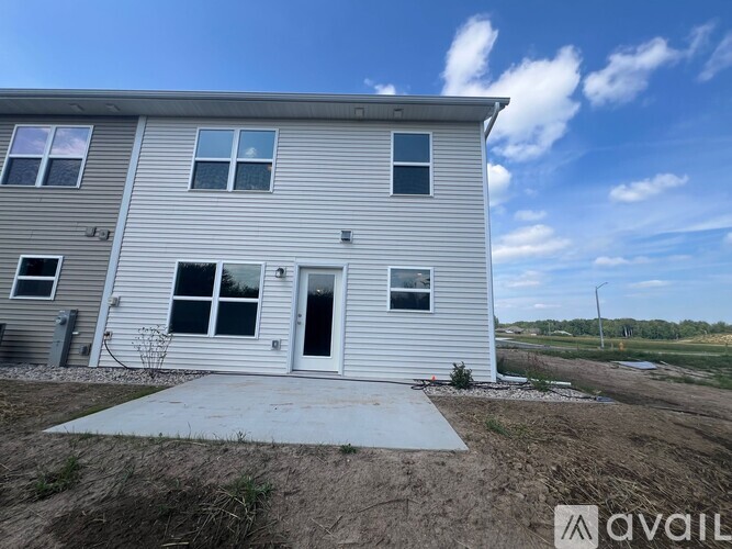 A two-story house with a grey exterior and a white door is available for purchase.