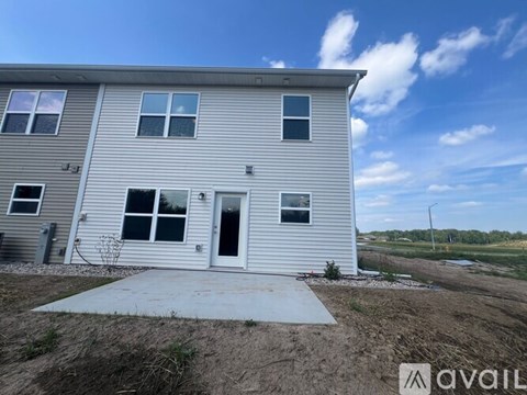 A two-story house with a grey exterior and a white door is available for purchase.
