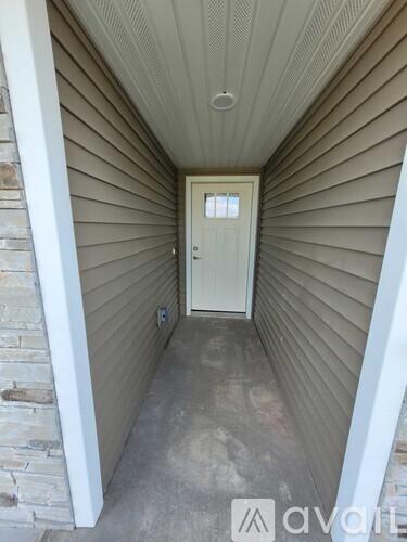 A hallway with a door and a stone wall.