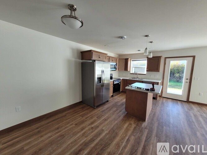 A kitchen with wooden floors and a refrigerator.