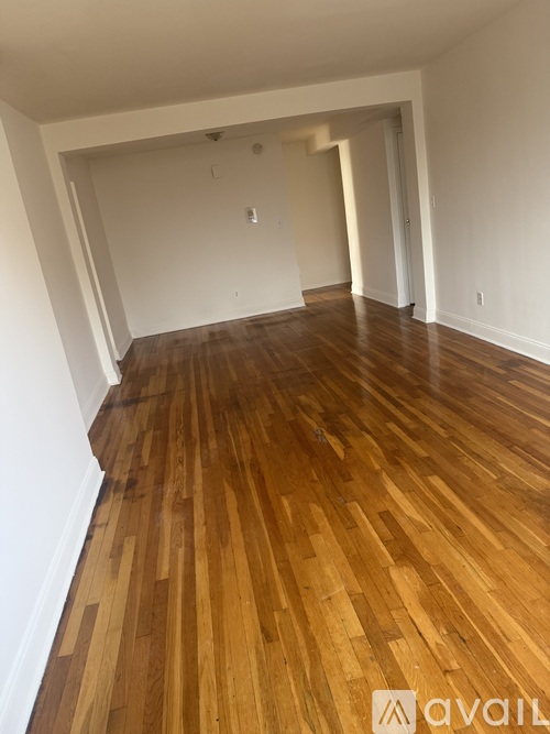 A room with wooden flooring and white walls.