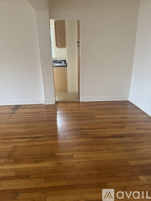 A room with wooden flooring and a white wall.