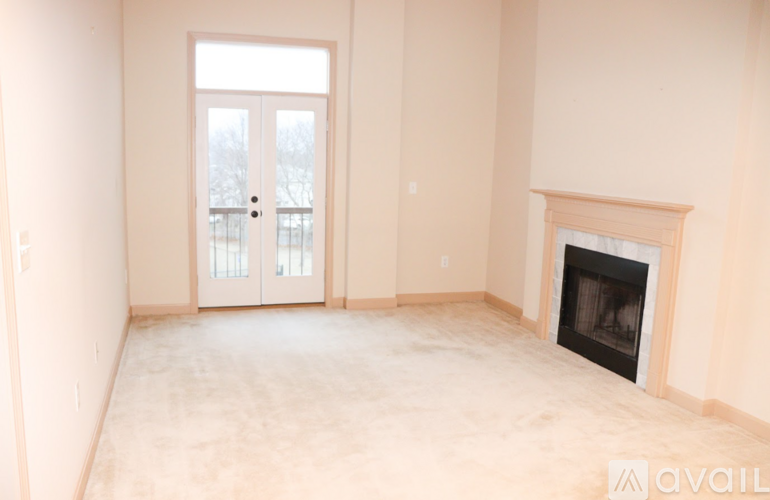 A room with a fireplace and a door with a view outside.