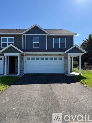 A two-story house with a garage is available for sale.