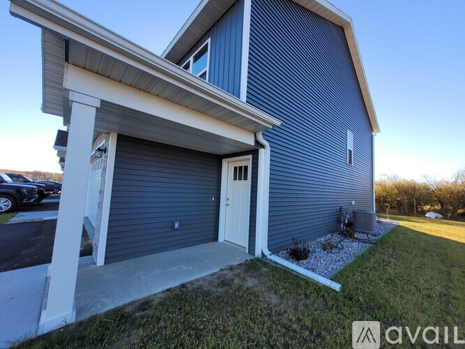 A blue house with a white garage door and a small garden in front.