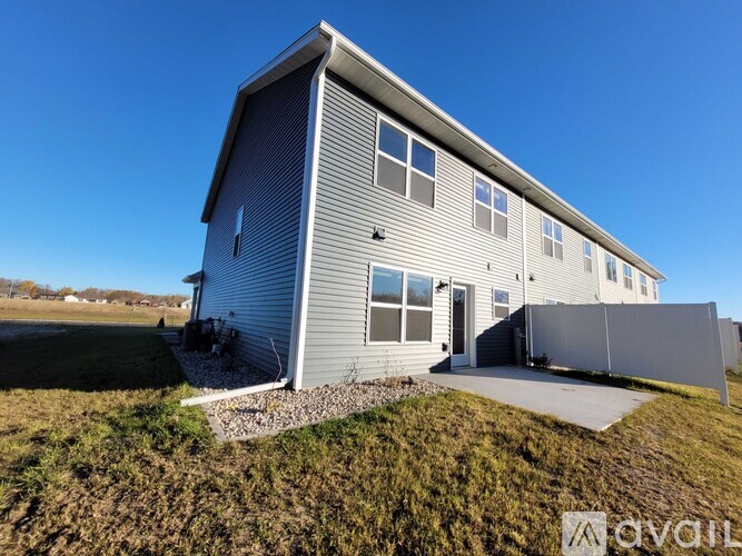 A grey house with a white fence in front.