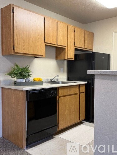 A kitchen with wooden cabinets and black appliances.