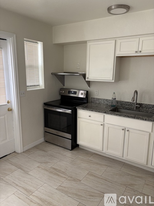 A kitchen with a black oven and white cabinets.