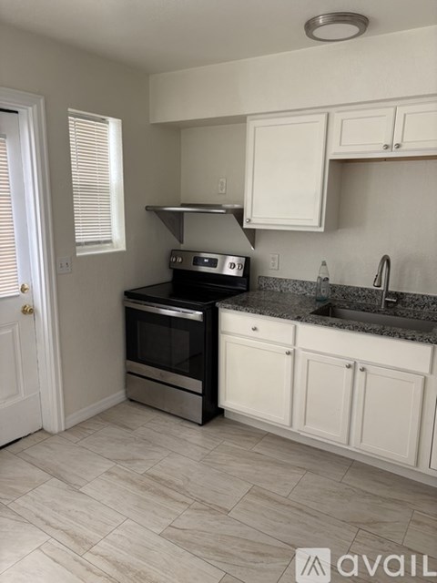 A kitchen with a black oven and white cabinets.