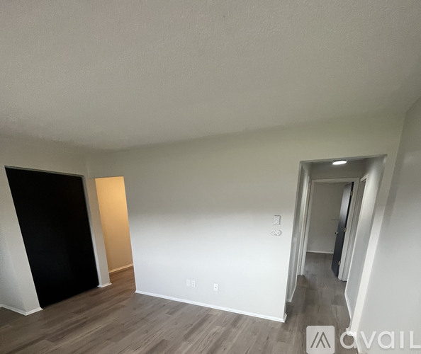 A room with a black door and a white wall with a small window.