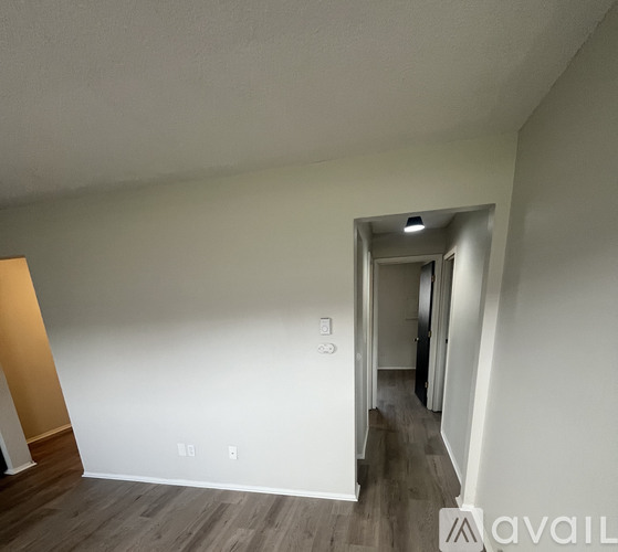 A room with a white wall and a wooden floor.