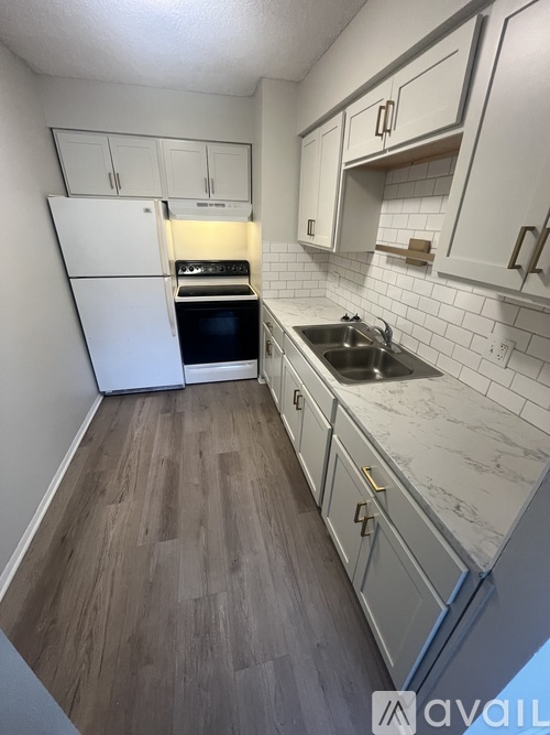 A kitchen with white cabinets and a white fridge.