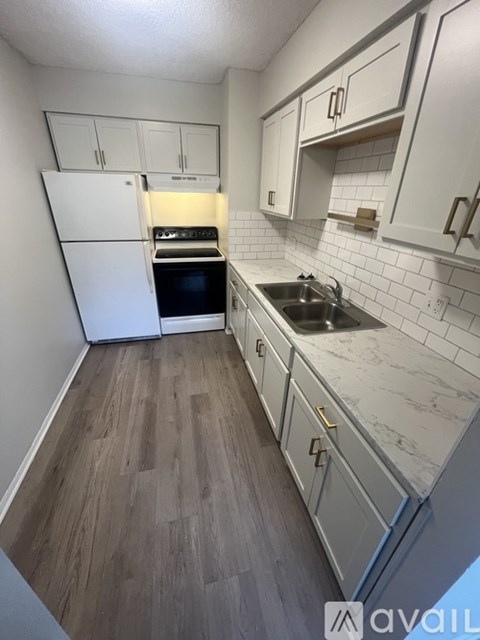 A kitchen with white cabinets and a white fridge.