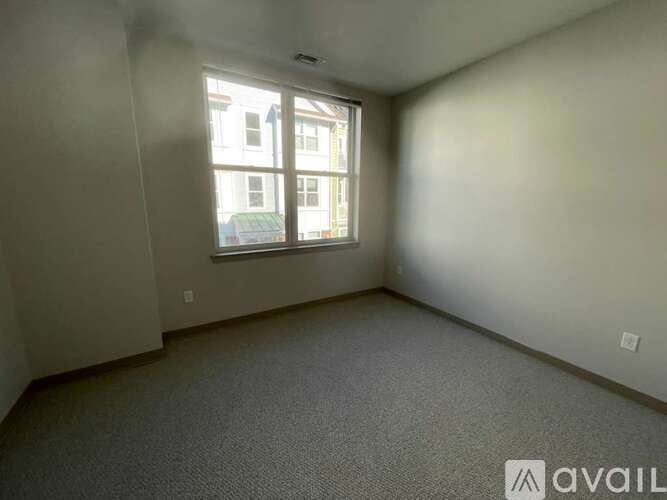 A room with a carpeted floor and a window.