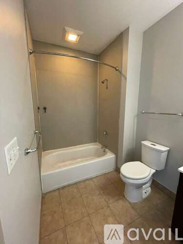 A bathroom with a toilet, tub, and shower.
