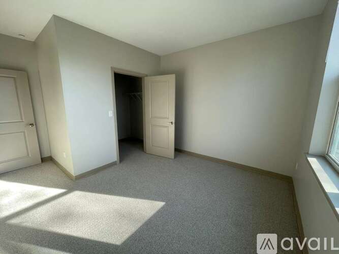A room with a carpet, a door and a window.