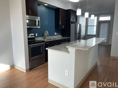 A kitchen with a white island and stainless steel appliances.