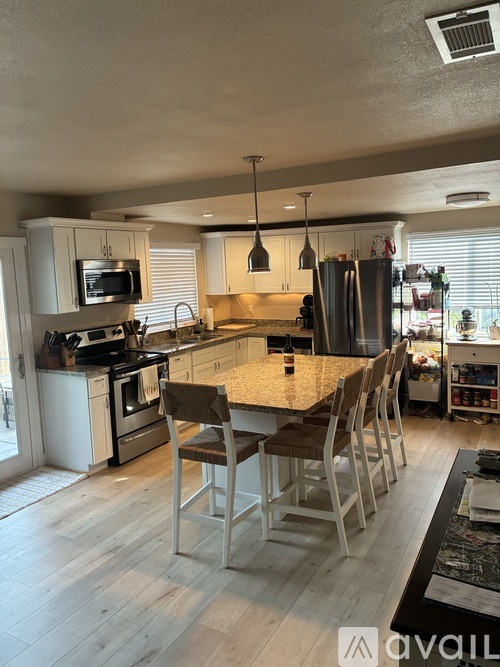 A kitchen with a table and chairs in the middle of the room.
