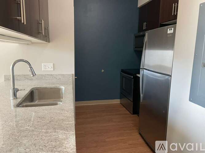A kitchen with a sink, refrigerator, and oven.