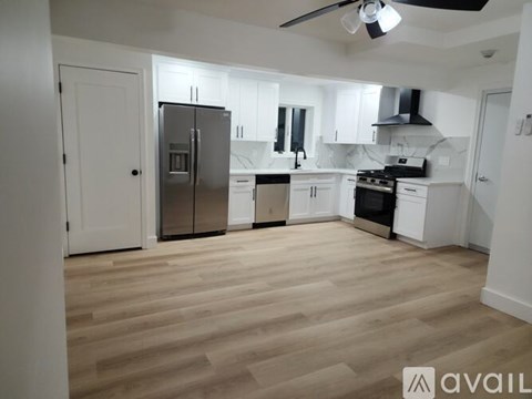 A kitchen with white cabinets and a wooden floor.