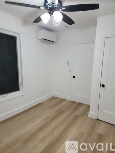 A room with a ceiling fan and a window.