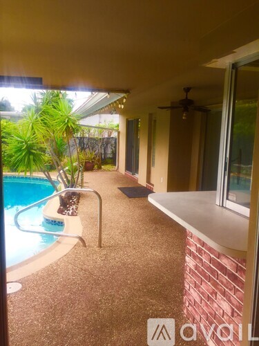 A pool with a chair and a table is in the middle of a patio.