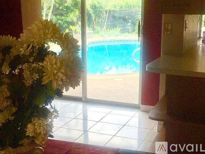 A bouquet of flowers sits in front of a glass door leading to a pool.