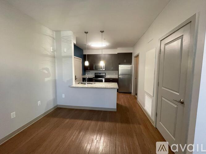 A kitchen area with a countertop and cabinets is visible through a window.