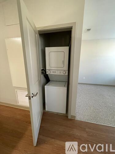 A small white kitchen appliance sits in a cabinet in a modern kitchen.