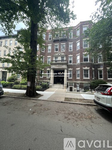 A street view of a building with the text "Boston Real Estate" on the facade.