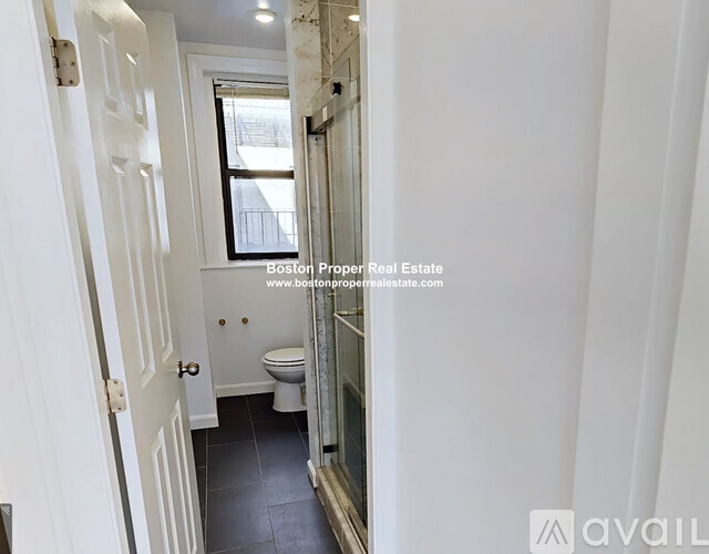 A bathroom with a toilet, sink, and mirror.