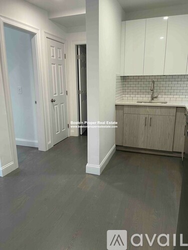 A kitchen area with white cabinets and a tiled backsplash.