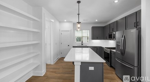 A modern kitchen with a white island and stainless steel appliances.