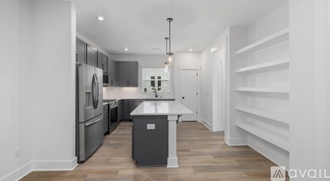 A modern kitchen with a refrigerator, oven, and sink.