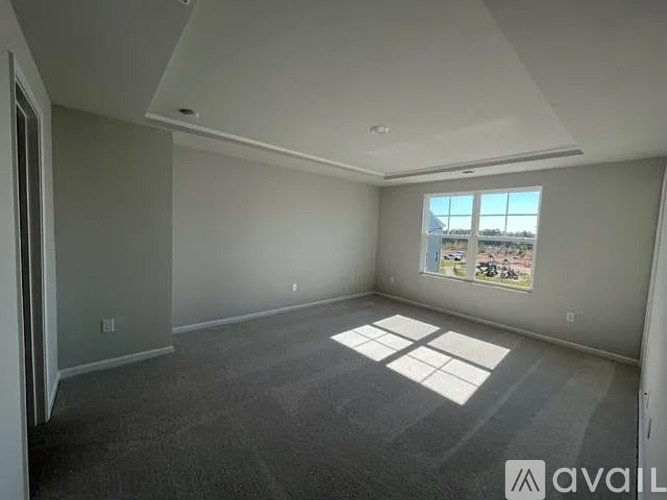 A spacious room with a large window and a view of the city.