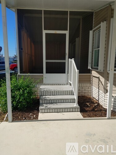 A white chair is on the porch of a house.